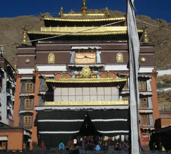 The ornate facade of Kelsang Temple at Tashi Lhunpo Monastery in Shigatse, Tibet, with golden roofs.