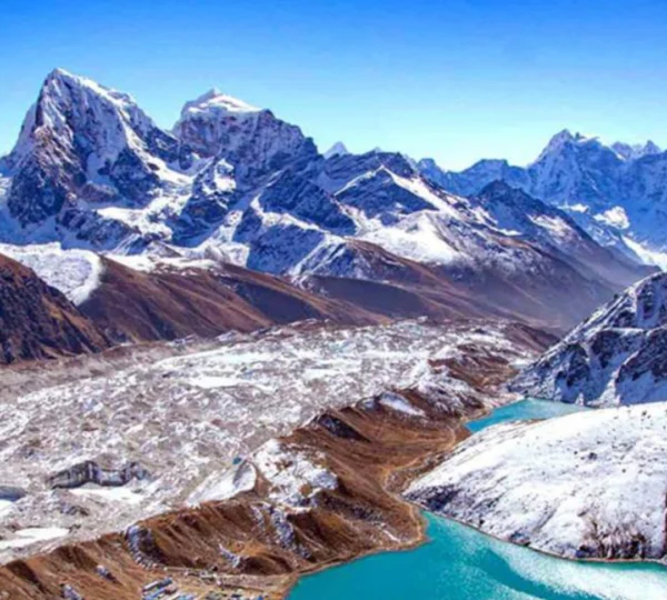 Rocky, snow-covered Cho-La Pass in the Everest region, with prayer flags and towering Himalayan peaks under a clear sky.