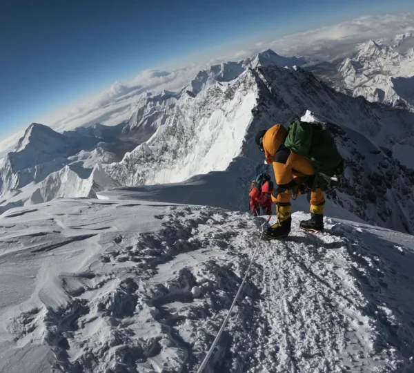 Mountaineer standing on the summit of Mount Everest